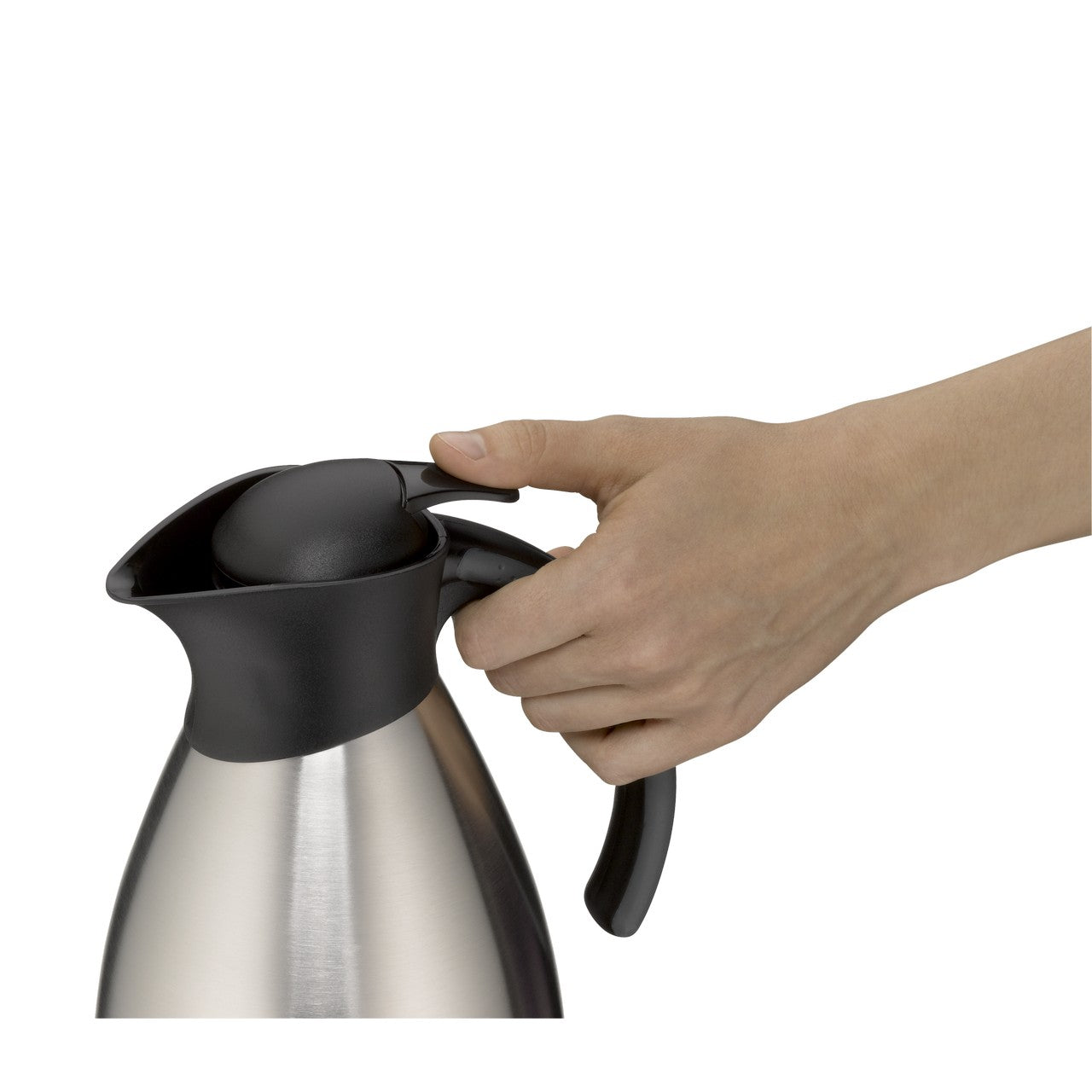 Eine Hand hält den Griff einer silbernen Isolierkanne mit einem schwarzen Deckel und Ausguss. Der Finger drückt auf einen Hebel, der wahrscheinlich zum Ausgießen dient.