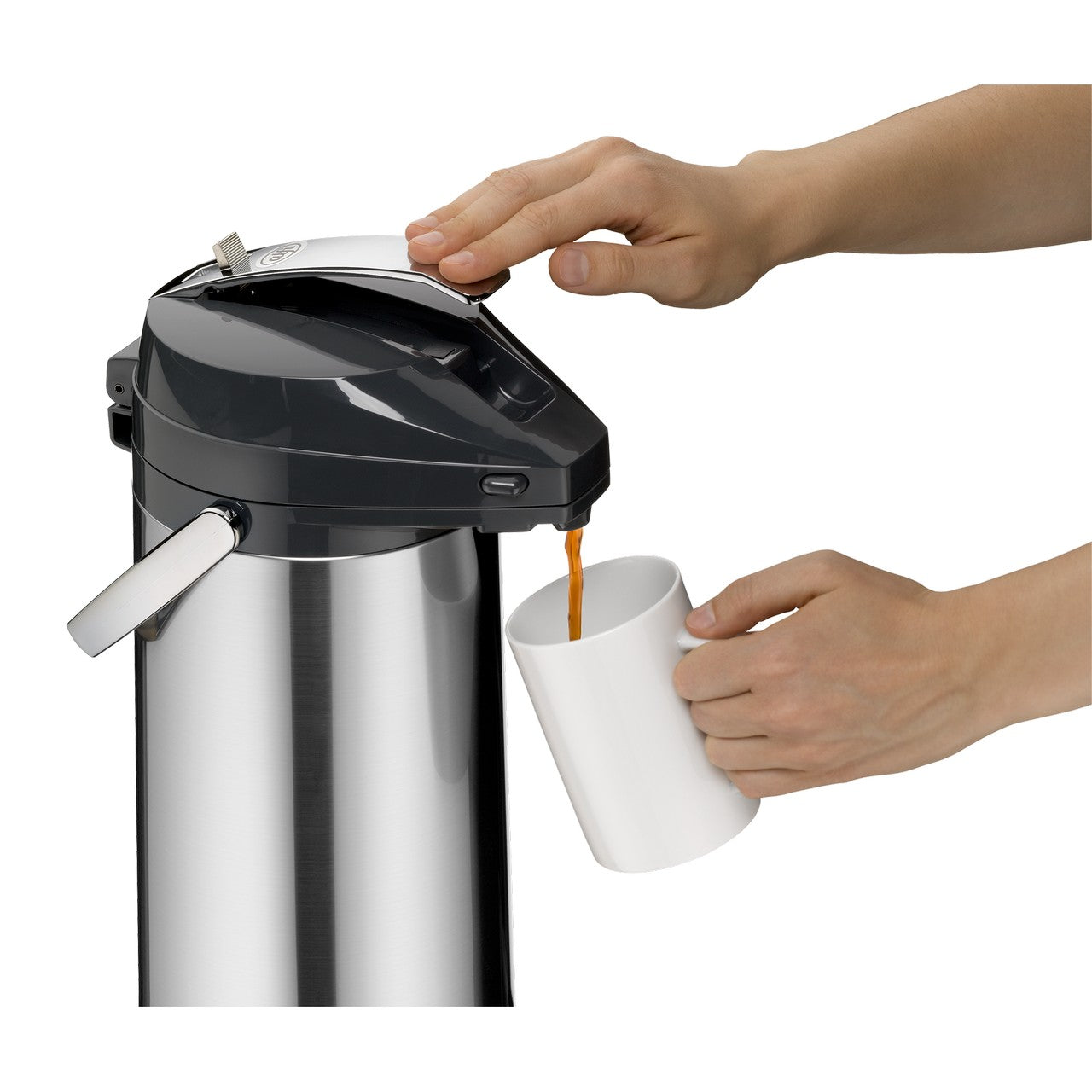 Auf dem Bild sieht man einen silbernen Pumpkannen-Thermos mit einem schwarzen Deckel. Eine Hand drückt den Hebel auf dem Deckel, während eine andere Hand eine weiße Tasse darunter hält, um Kaffee einzuschenken.