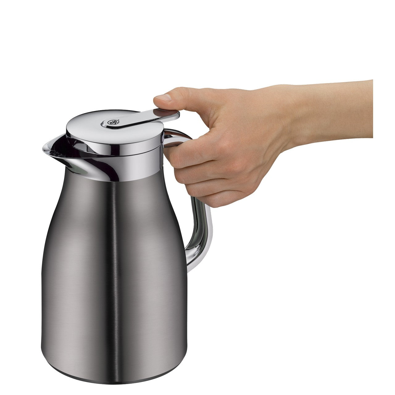 Eine Hand drückt auf den Deckel einer silbernen Thermoskanne. Die Kanne hat eine glänzende Oberfläche mit einem geschwungenen Griff.