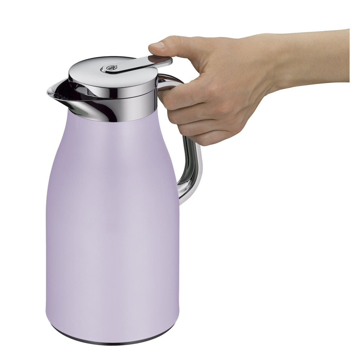 In der Bildmitte steht eine lila Thermoskanne mit silbernem Deckel. Der Tisch ist mit Tassen, Obst und einer Müslischale gedeckt. Im Hintergrund sind unscharfe Tassen und ein Korb.