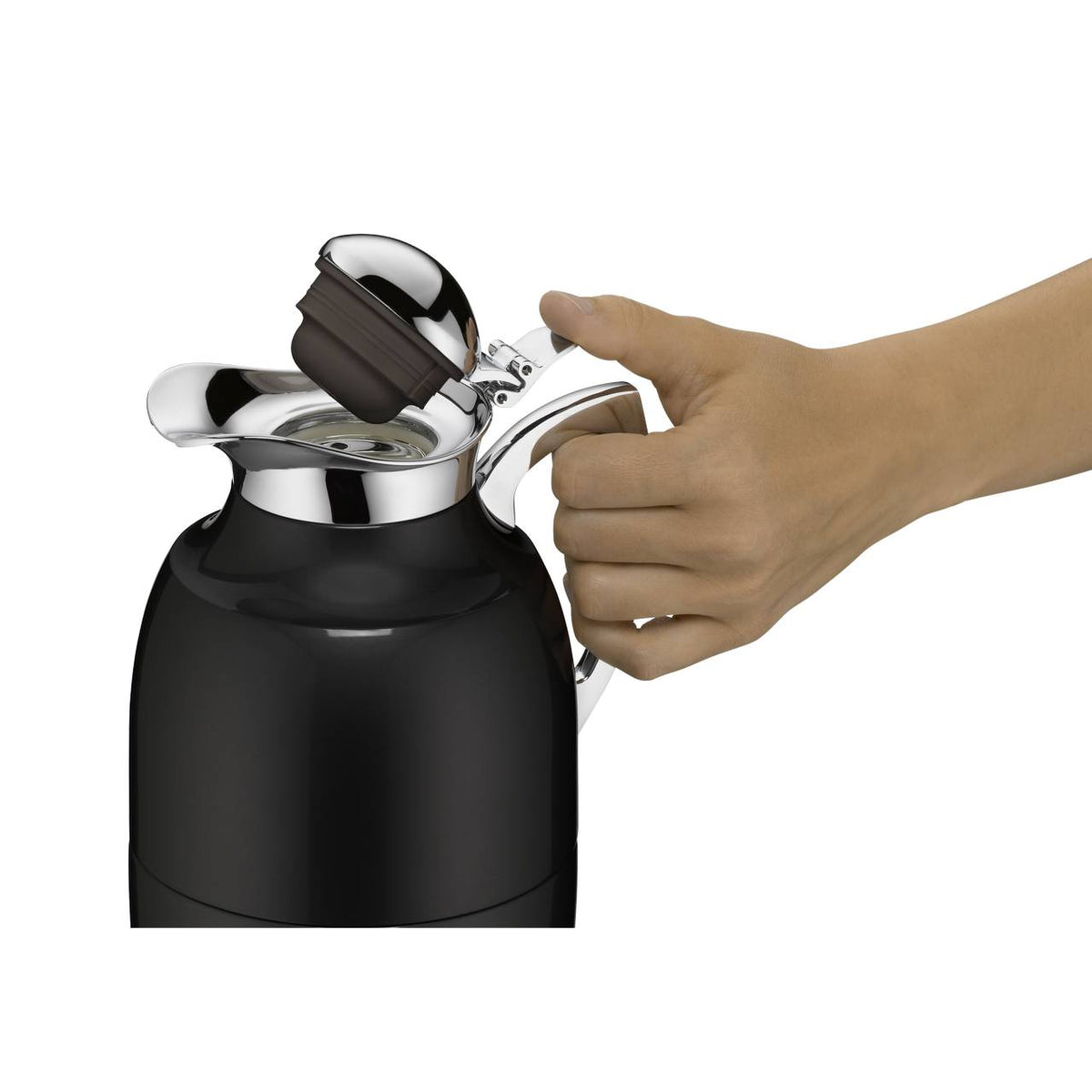 Eine Hand hält eine schwarze Thermoskanne, deren glänzender, silberfarbener Deckel geöffnet ist. Der Deckel hat einen schwarzen Griff und wird leicht angehoben.