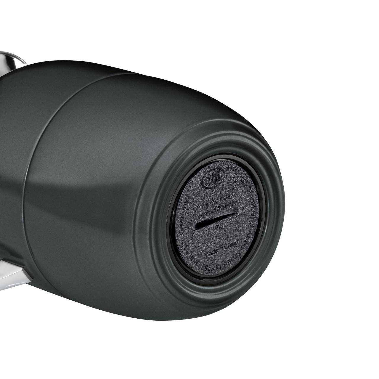 Das Bild zeigt einen schwarzen Drehknopf mit einer geriffelten Textur und einer leichten Wölbung. Auf der Oberfläche befinden sich eingeprägte Zahlen und Schriftzeichen, die auf der schwarzen Abdeckung sichtbar sind.