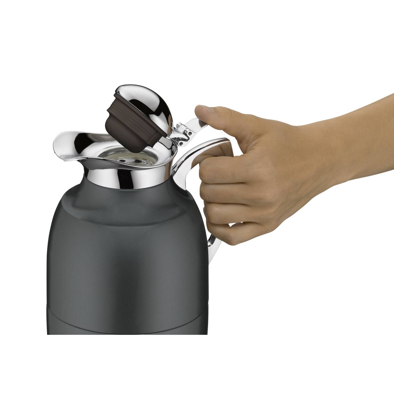 Eine Hand hält den Griff einer grauen Thermoskanne mit einem glänzenden Deckel. Der Deckel ist leicht geöffnet, um den Inhalt der Kanne zugänglich zu machen.
