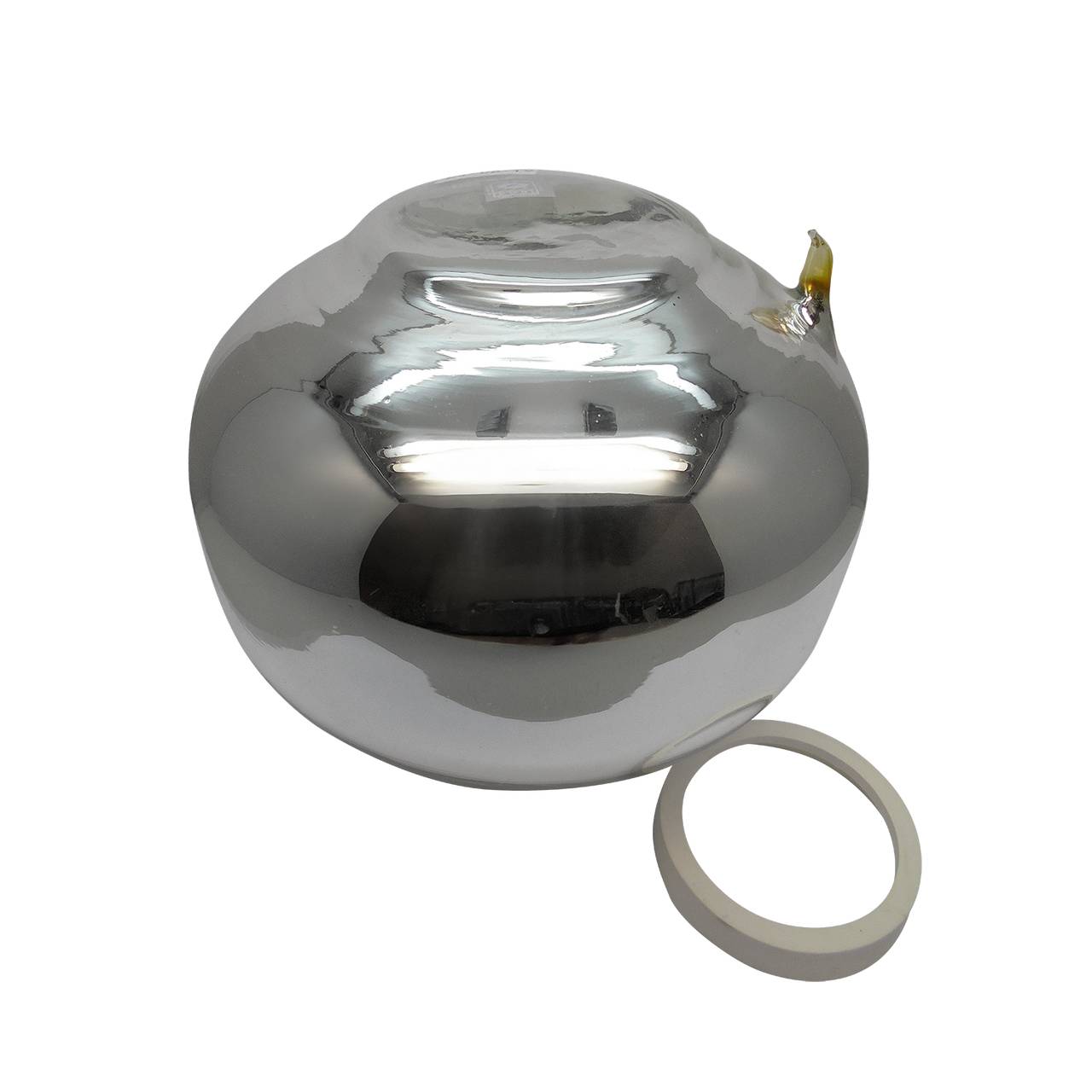 Das Bild zeigt einen glänzenden, silbernen Metallball mit einem kleinen Ausguss an der Seite. Daneben liegt ein separater, weißer Ring. Der Ball reflektiert das Licht stark und hat eine glatte Oberfläche.