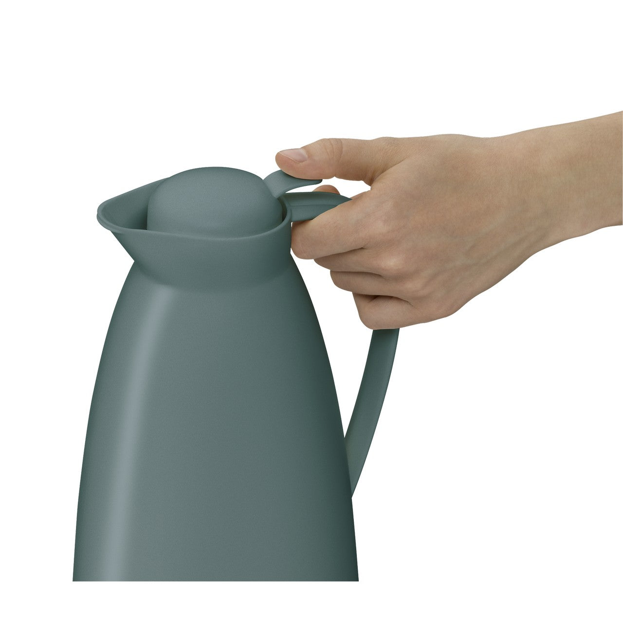 Auf einem Tisch steht eine blaue Thermoskanne. Daneben sind eine Topfpflanze mit grünen Sukkulenten und ein Stapel gelber Bücher zu sehen. Im Hintergrund fällt sanftes Tageslicht durch ein Fenster.