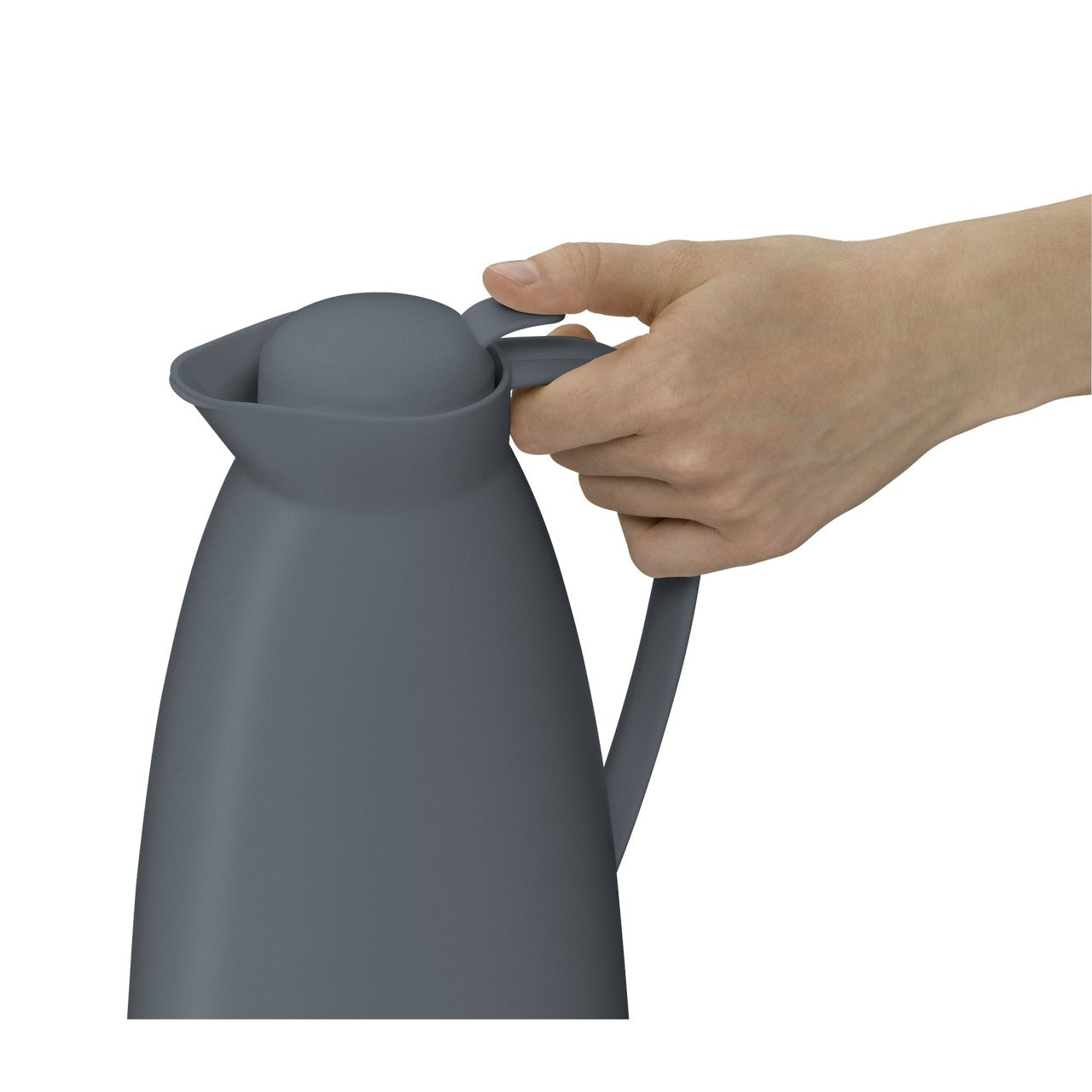 Auf einem kleinen Tisch stehen eine dunkle Thermoskanne und eine Tasse. Daneben liegen Zitrusfrüchte und ein Keks. Im Hintergrund ist ein Sessel mit einem gestreiften Kissen und einem offenen Buch.