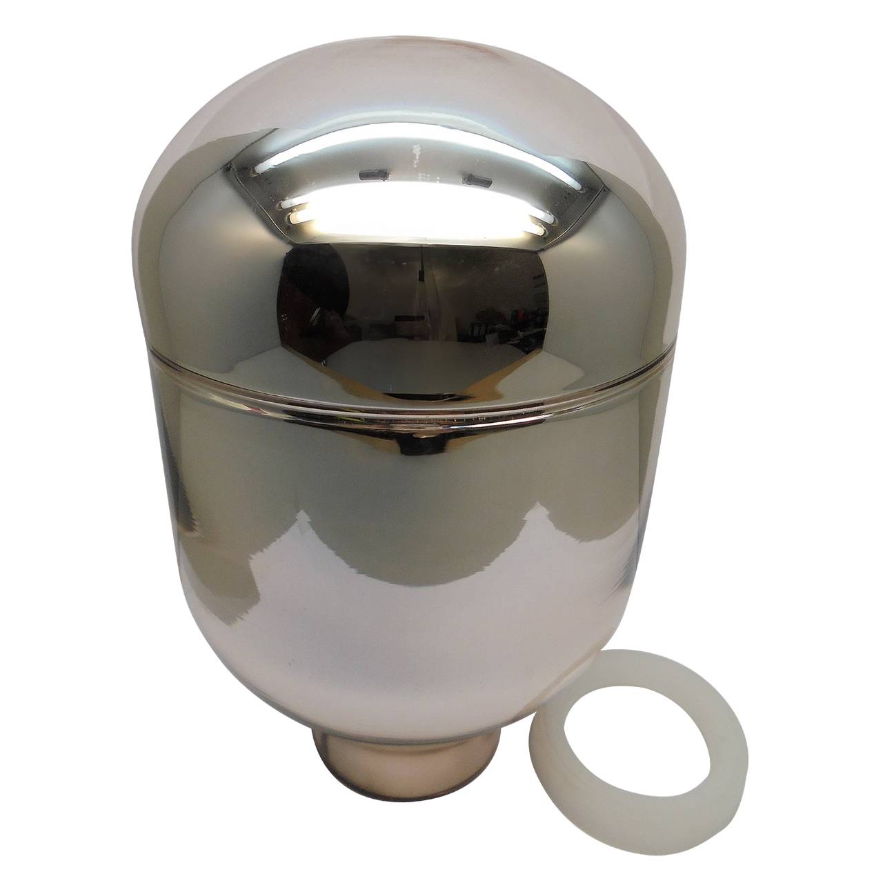 Das Bild zeigt einen glänzenden, silbernen Behälter mit einer abgerundeten Oberseite, ähnlich einer Kuppel. Neben dem Behälter liegt ein weißer Ring, der möglicherweise als Dichtung dient. Die Oberfläche des Behälters spiegelt das Licht wider.