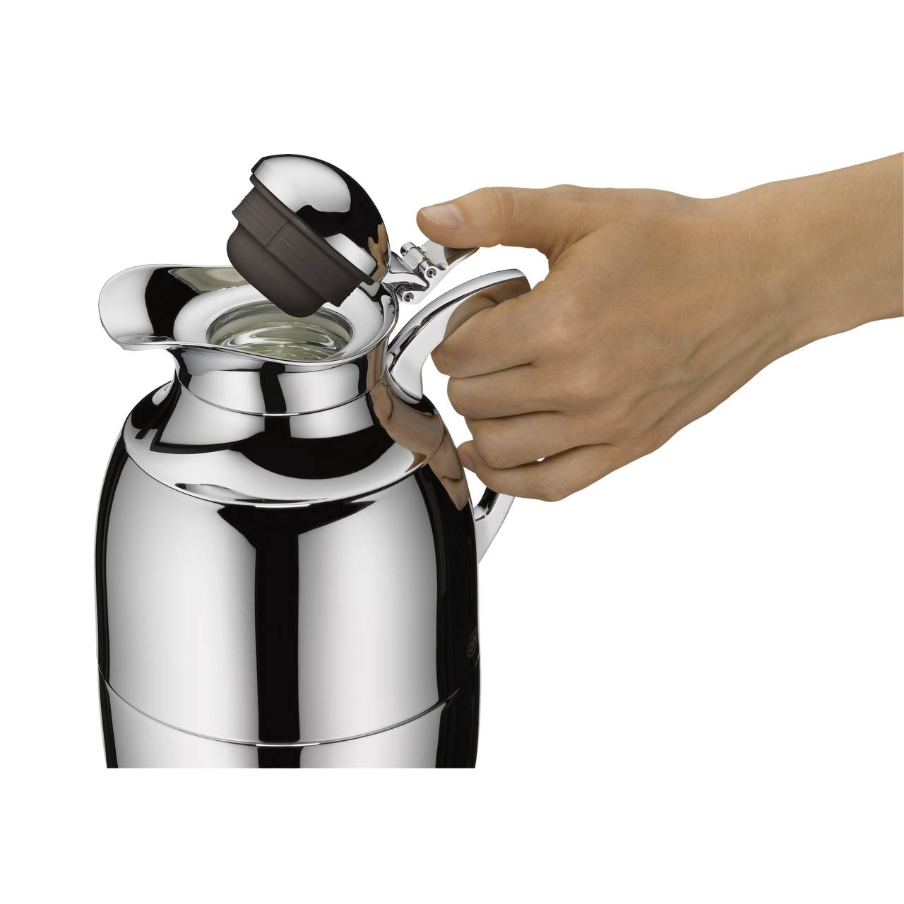 Eine Hand hält den Griff einer glänzenden, silbernen Thermoskanne. Der Deckel der Kanne ist geöffnet und leicht nach hinten gekippt.